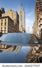 The Empire State Building and its reflection viewed on the hood of a car, New York City, Manhattan, United States of America