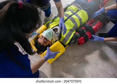 Employee accident in construction site work. Team EMS paramedic first aid for head injuries. Paramedic team first aid builder accident in site work. Emergency service. First aid procedure. - Powered by Shutterstock