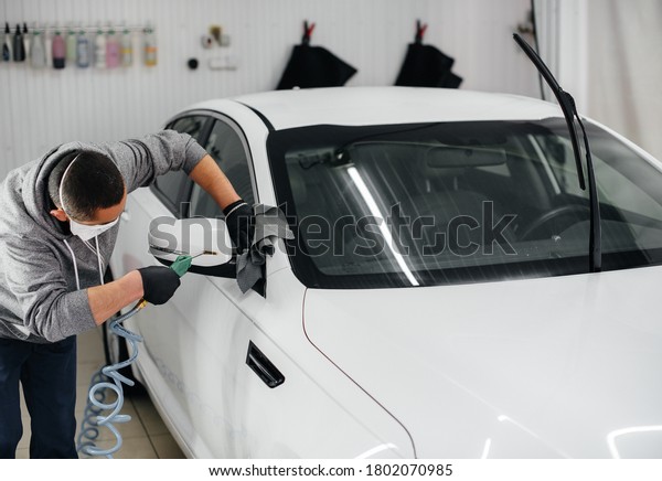 An employee blows and wipes the car after washing.
Car wash