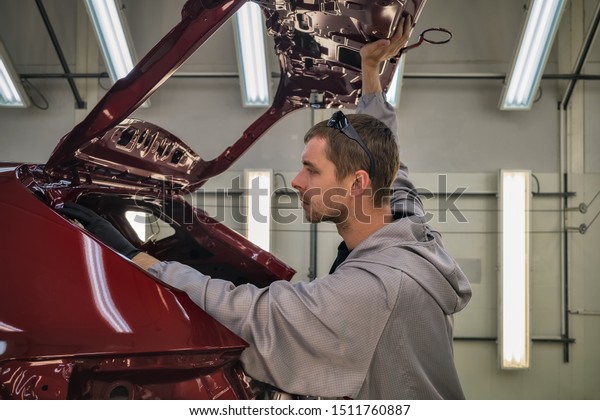 Employee car body painting shop checks the
quality of the painted
surface