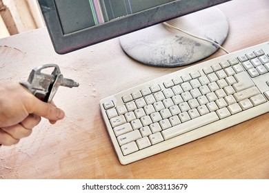 Employee Cleans A Dusty Keyboard And Dusty Desk With Air Duster Cleaning Spray Gun In The Workshop Closeup