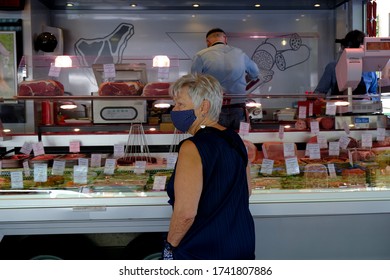 An Employee Of Cold Cuts Shop Wearing Protective Mask And Gloves Serves A Consumer  During The Open-air Market In Brussels Belgium, On May 18, 2020, Amid The Pandemic Of  (COVID-19).