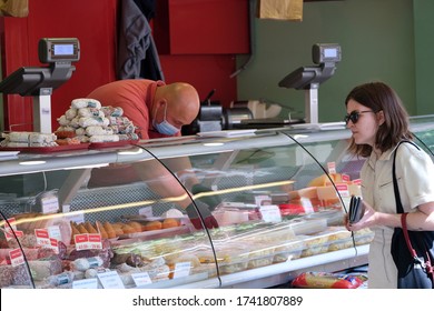 An Employee Of Cold Cuts Shop Wearing Protective Mask And Gloves Serves A Consumer  During The Open-air Market In Brussels Belgium, On May 18, 2020, Amid The Pandemic Of  (COVID-19).