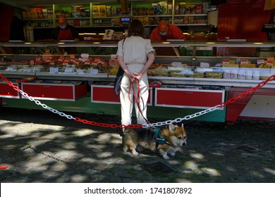 An Employee Of Cold Cuts Shop Wearing Protective Mask And Gloves Serves A Consumer  During The Open-air Market In Brussels Belgium, On May 18, 2020, Amid The Pandemic Of  (COVID-19).