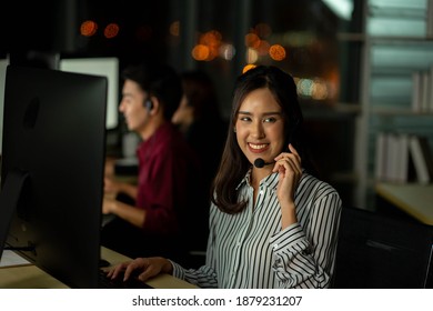 employee customer service representative working as technical support call center in the office with headphone computer overtime in the night - Powered by Shutterstock