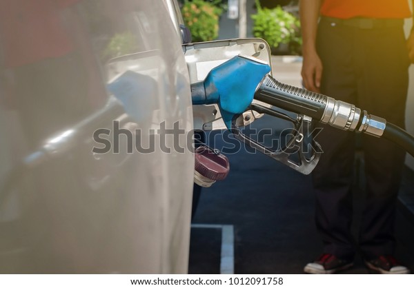 Employee fill fuel for\
car at oil station.
