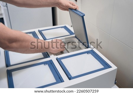 Employee of the genetic laboratory checks the incubator for embryos