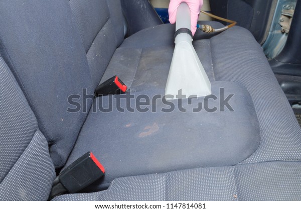 Employee hand\
cleaning dirty back seat with professionally extraction method.\
Early spring regular cleanup. Care about auto interior. Commercial\
cleaning company\
concept.