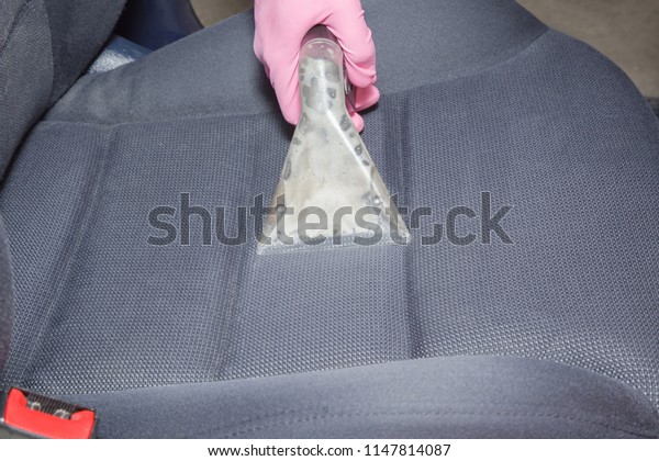 Employee hand\
cleaning dirty driver\'s seat with professionally extraction method.\
Early spring regular cleanup. Care about auto interior. Commercial\
cleaning company\
concept.