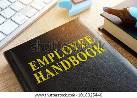 Employee handbook on a wooden desk.