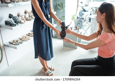 Employee Helping Customer Buying A New Shoes In Fashion Boutique Store