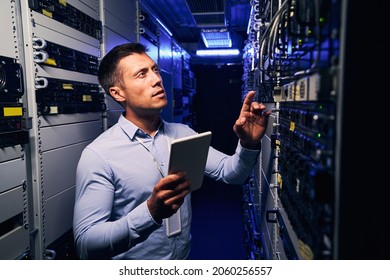 Employee inspecting hardware equipment in colocation center