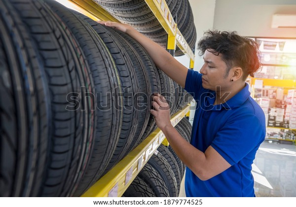 The\
employee inspects the tire as an inventory and checks the quality\
of the tires in the garage.Good service\
concept.
