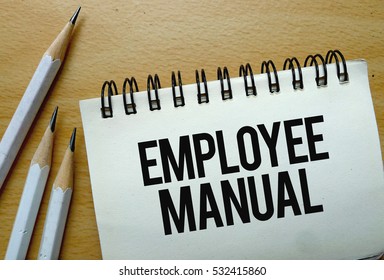 Employee Manual Text Written On A Notebook With Pencils