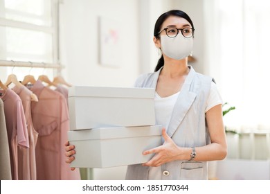 Employee In The New Normal Wearing Mask Carrying Shoe Boxes 