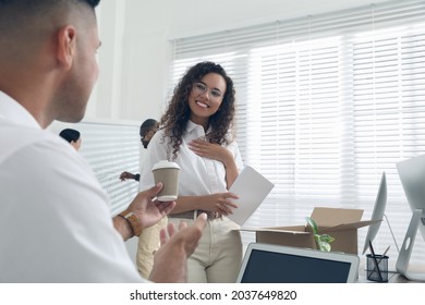 Employee offering cup of coffee to new coworker in office - Powered by Shutterstock