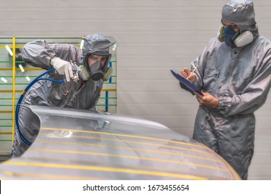 Employee Of The Paint Shop Of Automobile Factory Carries Out Training In The Painting Of Body Parts With Gun