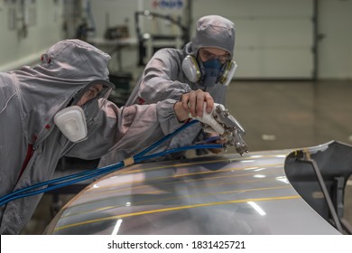 Employee Of The Paint Shop Of Automobile Factory Carries Out Training In The Painting Of Body Parts With Gun