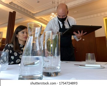 An Employee At Restaurant, Wearing A Protective Mask, Serves Customers As Restaurants And Bars Reopen After Weeks Of Lockdown Restrictions Amid The COVID-19 Outbreak, In Brussels, Belgium Jun. 9, 2020