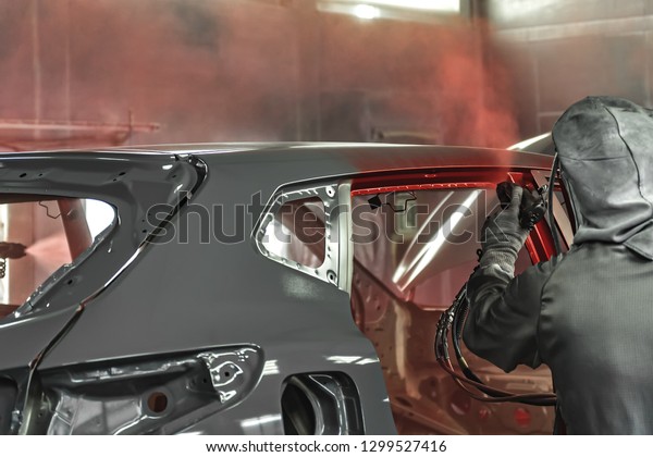 Employee in the shop\
painting the car body produces a painting of the interior elements\
of the car