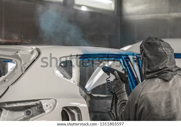 Employee in the shop\
painting the car body produces a painting of the interior elements\
of the car