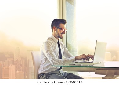 Employee Sitting At His Desk Using A Pc