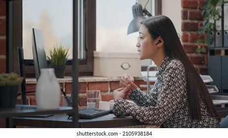 Employee talking to colleague on online video call to do remote business work in office. Person with earpods using video teleconference to chat with worker about project on computer.