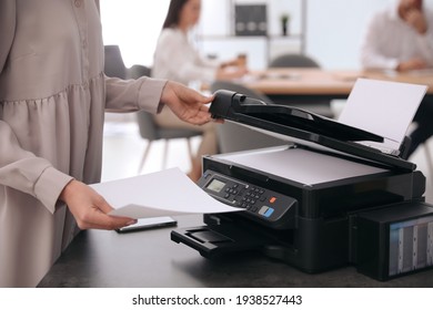 Employee using modern printer in office, closeup
