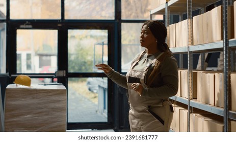 Employee in warehouse using AR holographic technology to visualize how to best stack merchandise on shelves to make room for more. Worker in storage establishment uses augmented reality - Powered by Shutterstock