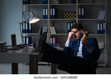 Employee Working Late And Drinking Strong Coffee To Stay Awake