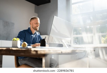 Employee Working On Desktop Computer In Home Office - Powered by Shutterstock