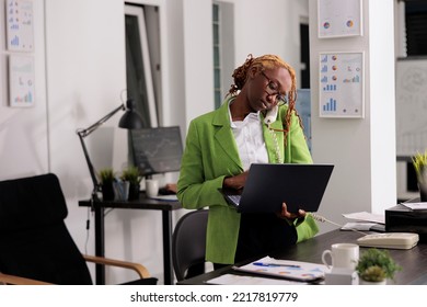 Employee working on laptop, answering landline phone call, having remote conversation with coworker. Office worker discussing company financial strategy at startup project - Powered by Shutterstock