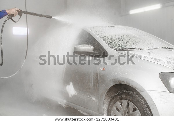 the employee works in the car wash. wash dirty car\
with foam in car wash