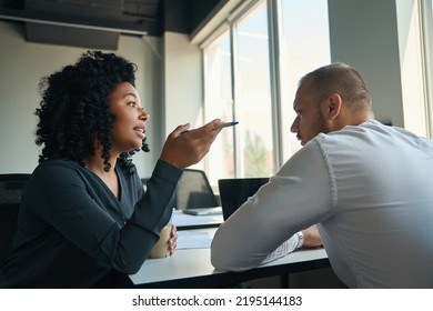 Employees Chatting At A Desk In A Simple Bright Office