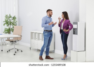 Employees having break near water cooler in office. Space for text - Powered by Shutterstock