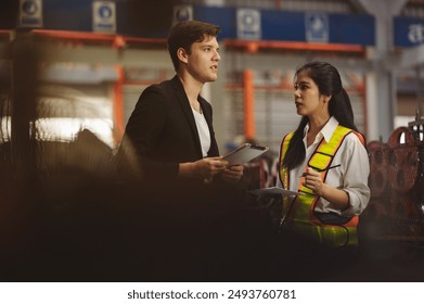 Employees and managers inspect work in a metal roofing factory that is responsible for using electric tools and engines to produce metal sheet products. - Powered by Shutterstock