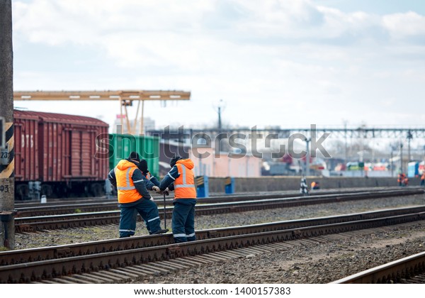 Employees of railway depot\
inspect repair and maintenance of railway rails in order to detect\
breakdowns and ensure safety of trains on railway movement with\
copy space.
