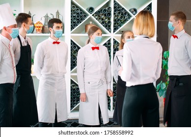 Employees Of A Restaurant Or Hotel In Protective Masks. End Of Quarantine. Restaurant Manager And His Staff On The Terrace. Interaction With The Chef In The Restaurant
