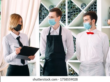 Employees Of A Restaurant Or Hotel In Protective Masks. End Of Quarantine. Restaurant Manager And His Staff On The Terrace. Interaction With The Chef In The Restaurant