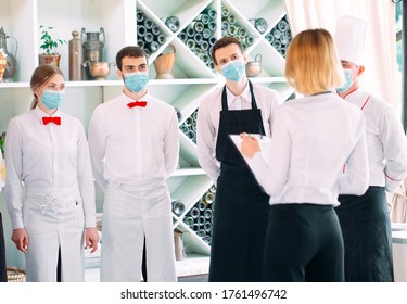 Employees Of A Restaurant Or Hotel In Protective Masks. End Of Quarantine. Restaurant Manager And His Staff On The Terrace. Interaction With The Chef In The Restaurant