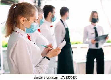 Employees Of A Restaurant Or Hotel In Protective Masks. End Of Quarantine. Restaurant Manager And His Staff On The Terrace. Interaction With The Chef In The Restaurant