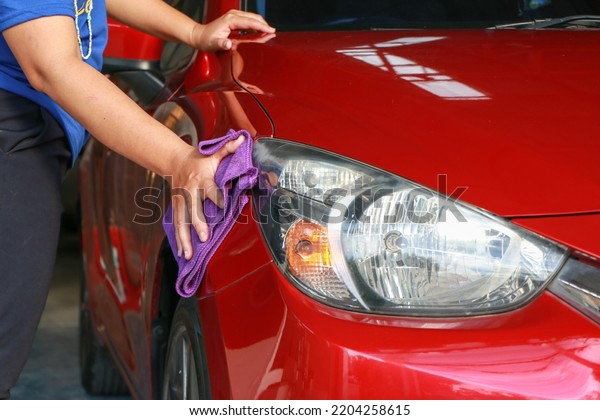 Employees are wiping the car to clean the car\
before delivering it to the\
customer.