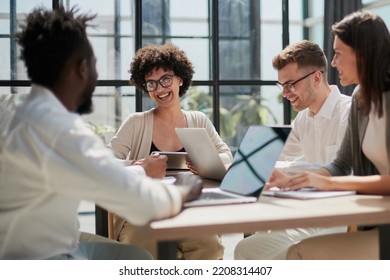 Employees working at computer together, discussing content - Shutterstock ID 2208314407