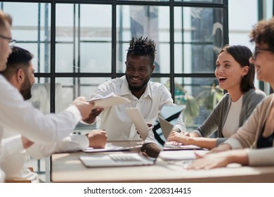 Employees working at computer together, discussing content - Shutterstock ID 2208314415
