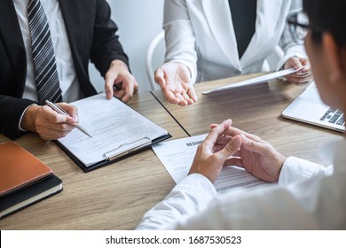 Employer or committee holding reading a resume with talking during about his profile of candidate, employer in suit is conducting a job interview, manager resource employment and recruitment concept. - Shutterstock ID 1687530523