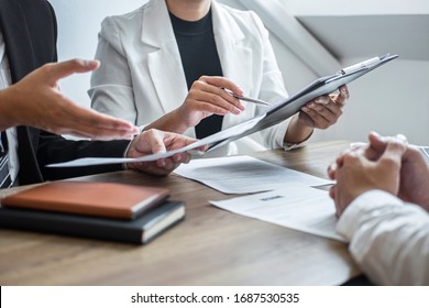 Employer or committee holding reading a resume with talking during about his profile of candidate, employer in suit is conducting a job interview, manager resource employment and recruitment concept.
