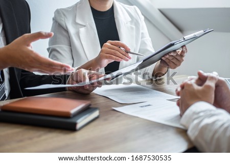 Employer or committee holding reading a resume with talking during about his profile of candidate, employer in suit is conducting a job interview, manager resource employment and recruitment concept.