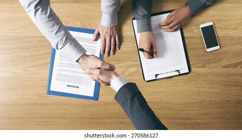 Employer Hiring And Giving An Handshake To The Candidate After The Job Interview, Hands Close Up Top View