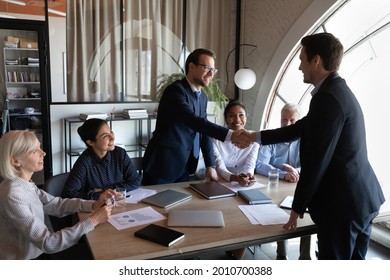 Employer, hr managers welcoming new employee to team, giving handshake to candidate at job interview. Diverse group of clients thanking professional for help, leader shaking hand on meeting - Shutterstock ID 2010700388