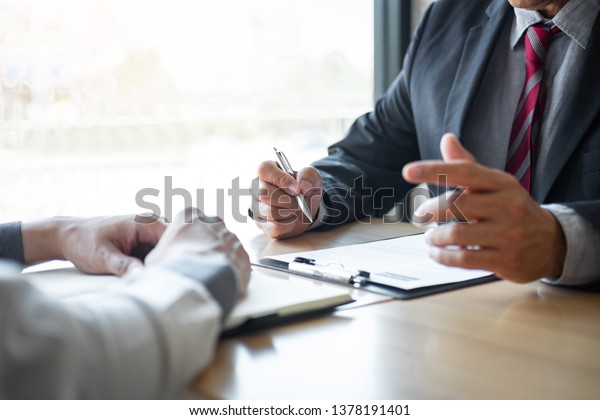 Employer or recruiter holding reading a resume\
during about colloquy his profile of candidate, employer in suit is\
conducting a job interview, manager resource employment and\
recruitment concept.